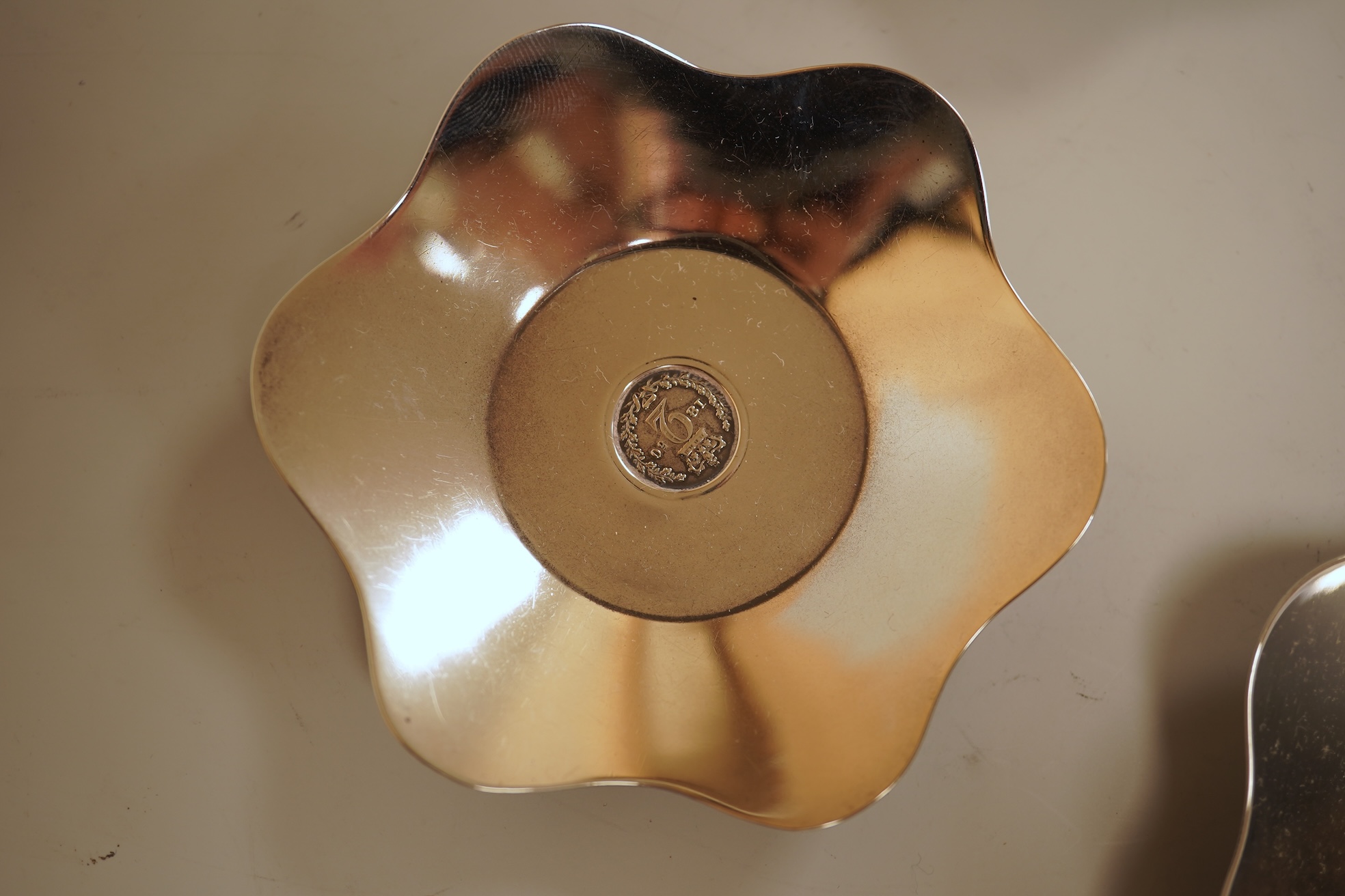 A cased set of four George V silver flower head shaped nut dishes, each inset with an 1850 maundy coin, Walker & Hall, Birmingham, 1936, diameter 77mm.